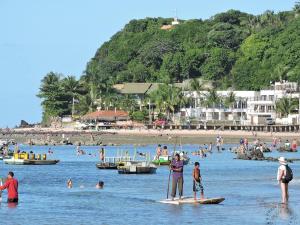 een groep mensen in het water op een strand bij RESORT SOLAR PIPÁ CASA 24 in Pipa