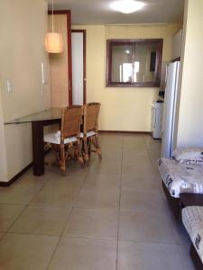 een keuken met een eettafel en stoelen bij RESORT SOLAR PIPÁ CASA 24 in Pipa