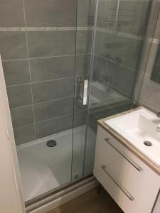 eine Dusche mit Glastür neben einem Waschbecken in der Unterkunft Appartement T2 de 40m2 refait à neuf pour vous ! Climatisé in La Grande-Motte