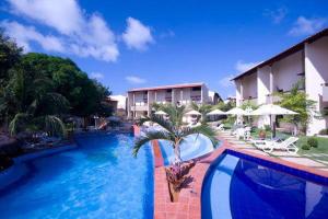 RESORT SOLAR PIPA CASA na frente da pisina في بيبا: مسبح بالنخيل بجانب مبنى