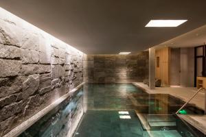 ein Pool in einem Raum mit einer Steinwand in der Unterkunft Chalet Mimi in Oberlech