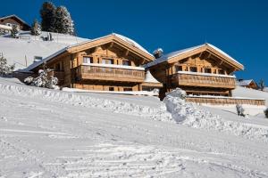 eine Blockhütte im Schnee vor in der Unterkunft Chalet Mimi in Oberlech
