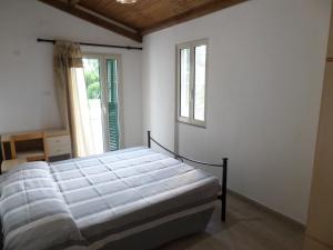a bedroom with a bed and two windows at agriturismo corallo in Santa Maria la Palma
