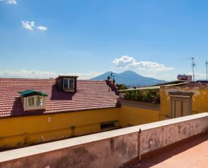 a view of the roofs of buildings with mountains in the background at Casa Vacanze Sapienza 29 in Naples