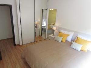1 dormitorio con 1 cama grande con almohadas amarillas en Comfy one bedroom in Palermo! en Buenos Aires