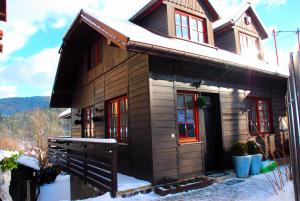 a small wooden house with snow on it at Domek w górach do wynajęcia i pokoje in Piwniczna-Zdrój