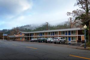a building with cars parked in a parking lot at The Angler Lodge in Dunsmuir