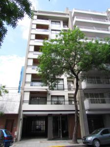 un edificio blanco alto con un árbol delante de él en Comfy one bedroom in Palermo! en Buenos Aires
