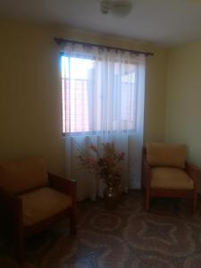 a waiting room with two chairs and a window at Casa Huespedes Angoba in Arica