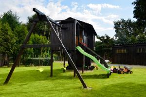 un parque infantil con un tobogán en un patio en Spreewaldpension Hahn, en Alt Zauche