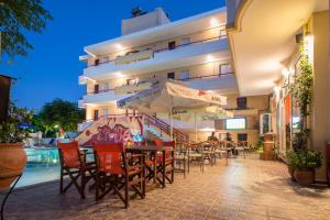a restaurant with tables and chairs in front of a building at Erato Studios & Apartments in Kos