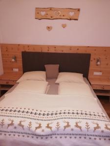 a bedroom with a large bed with a wooden headboard at Chalet Niederhaushof in Ultimo