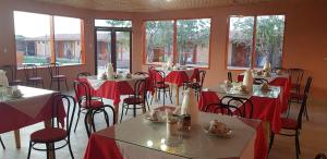 a dining room with tables and chairs with red table cloth at Ckausama North in San Pedro de Atacama
