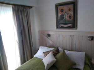 um quarto com uma cama com almofadas e uma janela em Estudio en Edificio Olagüe em Mar del Plata