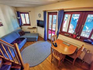 un soggiorno con divano blu e tavolo di Apartment Alpine Lake a Bled