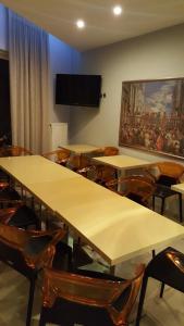 Cette chambre dispose de tables, de chaises et d'une télévision à écran plat. dans l'établissement Alexandros, à Kamena Vourla