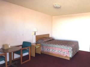 een hotelkamer met een bed en een tafel en stoelen bij Deluxe Inn Motel in Sparks