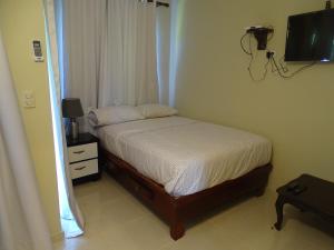 Dormitorio pequeño con cama y TV en Albatros Cabarete, en Cabarete