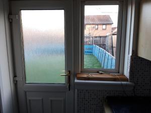 a door with a window and a view of the ocean at Hardgate Gardens in Glasgow