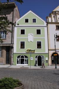 un edificio verde y blanco en una calle en Caramell, en Louny