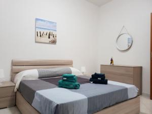 een slaapkamer met 2 bedden en een spiegel bij Appartamento TE&ME in Cefalù
