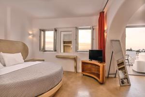 una camera con letto e TV su un tavolo di La Bellezza Eco Boutique Hotel a Kamari