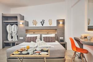 a hotel room with a tray of food on a bed at La Bellezza Eco Boutique Hotel in Kamari