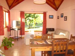 uma sala de estar com uma mesa e um sofá em CABANAS ´PORTAL NORTE em El Bolsón