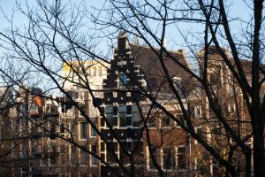 een hoog gebouw met een toren ervoor bij Rosalia's Menagerie Cocktail bar & InnUpstairs in Amsterdam