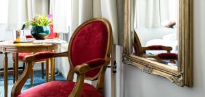 una silla roja sentada frente a un espejo en Rosalia's Menagerie InnUpstairs 'formerly misc eatdrinksleep', en Ámsterdam