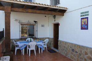 a dining room with a blue table and white chairs at Huerta Espinar - Casa rural con piscina privada in Archidona