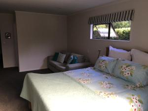 1 dormitorio con 1 cama y 1 sofá en Kerikeri Garden Homestead en Kerikeri