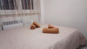 a bed with two teddy bears on top of it at Ruby room in Zagreb