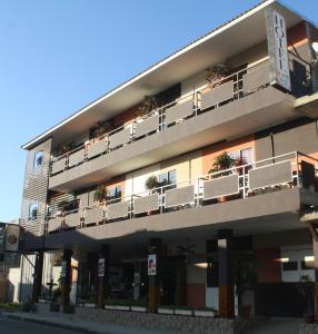 un edificio de apartamentos con balcones y plantas. en Hotel-Restaurante Ancora, en Puerto López