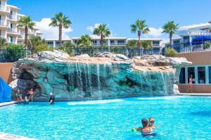 einen Pool mit Wasserfall in einem Resort in der Unterkunft Waterscape Resort by Tufan in Fort Walton Beach