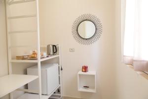 Camera bianca con specchio e scaffali bianchi di Tocco Barocco - Locazioni Brevi - a Ragusa