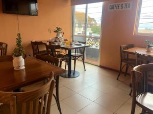 una sala da pranzo con tavoli, sedie e una finestra di Hotel Vidal a Pichilemu