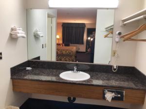 y baño con lavabo y espejo. en Luxury Inn en Norwalk