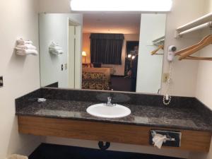 a bathroom with a sink and a mirror at Luxury Inn in Norwalk