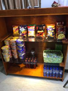 a shelf filled with different types of chips and drinks at Meaco Royal Hotel - Malabon in Manila