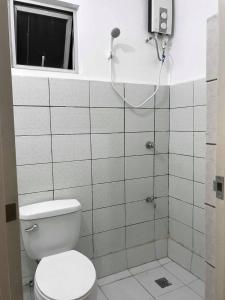 a bathroom with a toilet and a shower at Meaco Royal Hotel - Malabon in Manila