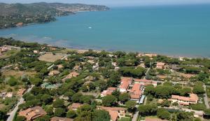 z góry widok na dzielnicę mieszkalną z jeziorem w obiekcie Airone RTA w mieście Orbetello