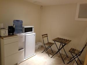 a kitchen with a microwave and a table and chairs at Your perfect stay away from home in Winnipeg