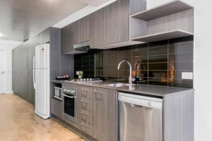 a kitchen with stainless steel appliances and wood cabinets at Direct Hotels - Pavilion and Governor on Brookes in Brisbane