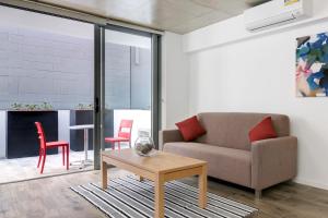 a living room with a couch and two red chairs at Direct Hotels - Pavilion and Governor on Brookes in Brisbane
