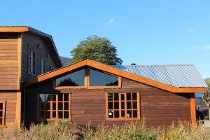 a wooden house with a metal roof at Los Mañíos Del Queulat Puyuhuapi in Puerto Puyuhuapi