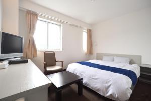a hotel room with a bed and a television at Uwajima Oriental Hotel in Uwajima
