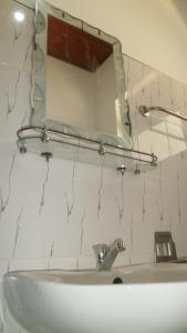 un lavandino in bagno con specchio sul muro di Sunny Lanka Guest House a Matara