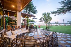 a patio with couches and chairs and a table at Vieng Khong Hotel in Mukdahan