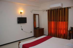 a bedroom with a bed and a television on the wall at Heritage Eco Resort Kelaniya in Kelaniya